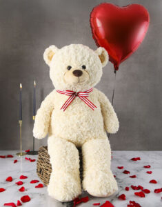 Big white teddy bear and a red balloon 