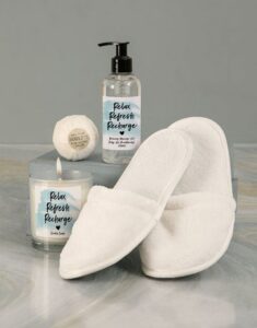 White scented candle, oil and white slippers 